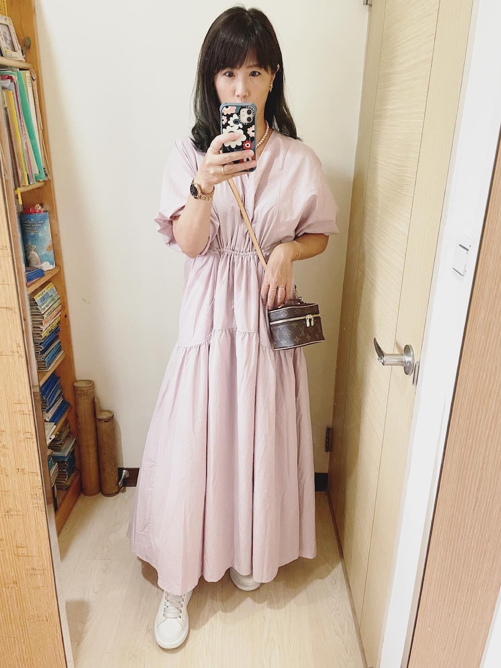 ピンク系のワンピース、ブラウン系のバッグ、ホワイト系のその他シューズを着用したレディースの夏コーディネートの2枚目の写真