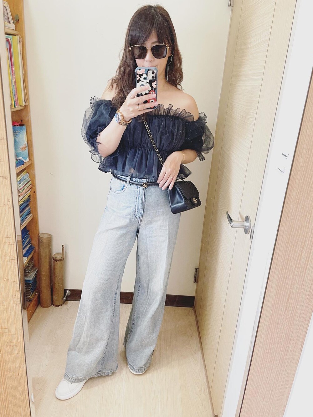 ブルー系のデニムパンツ、ホワイト系のその他シューズ、ブラック系のバッグを着用したレディースの春コーディネートの2枚目の写真