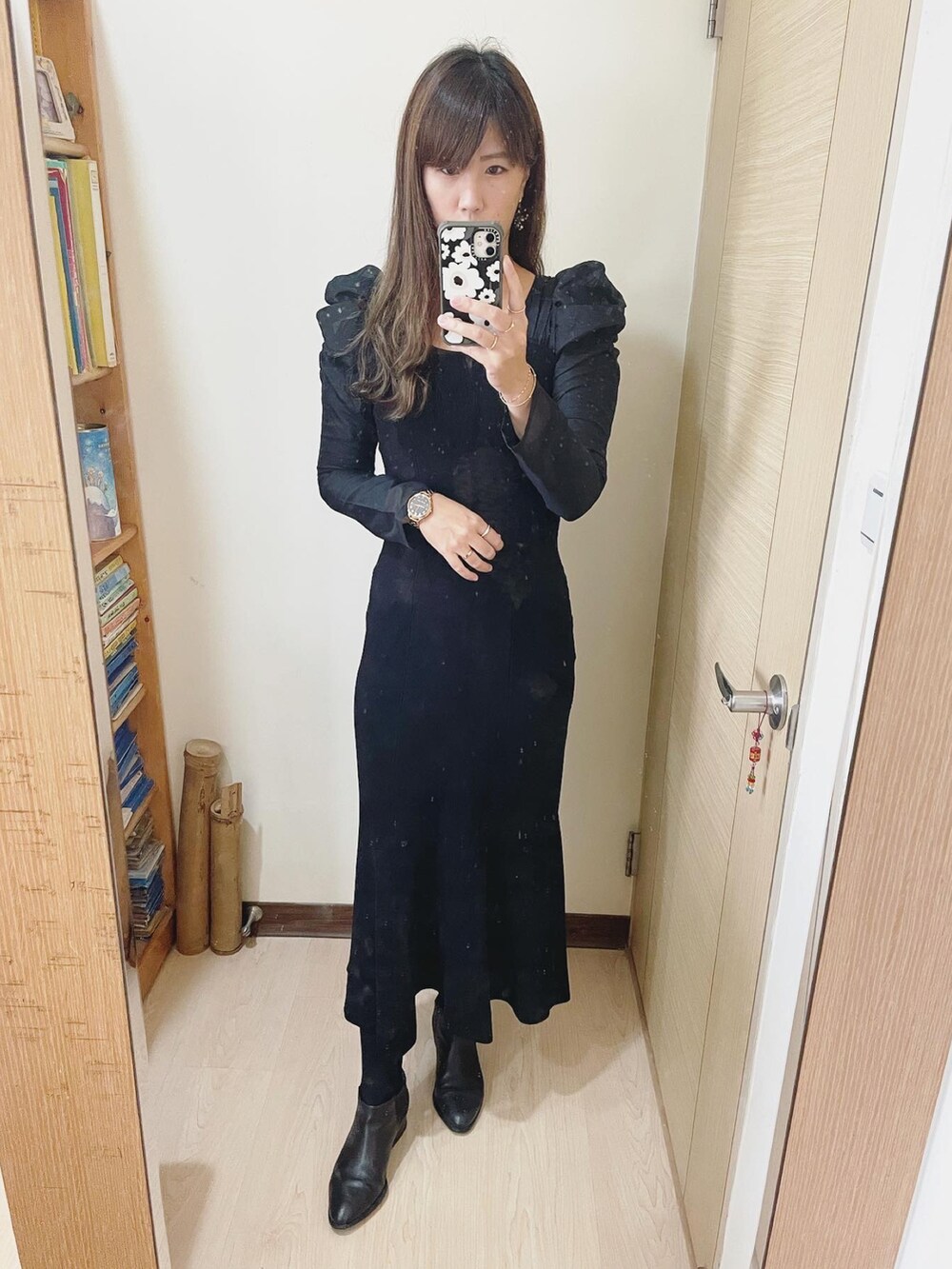 グレー系のバッグ、ブラック系のワンピース、ブラック系のブーツを着用したレディースの冬コーディネートの3枚目の写真