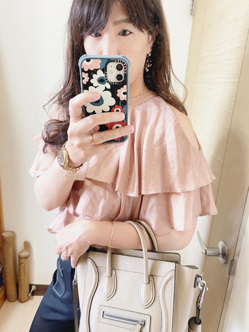 ベージュ系のトップス、ベージュ系のバッグ、ピンク系のシューズを着用したレディースの夏コーディネートの3枚目の写真