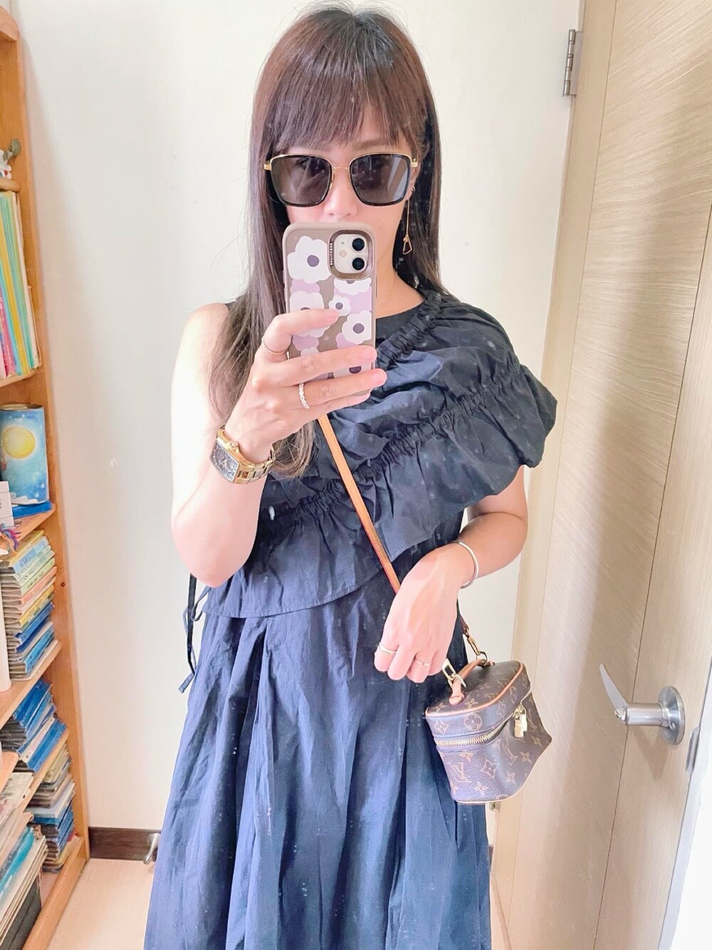 ブラック系のサンダル、ブラウン系のバッグ、ブラック系のワンピースを着用したレディースの夏コーディネートの2枚目の写真