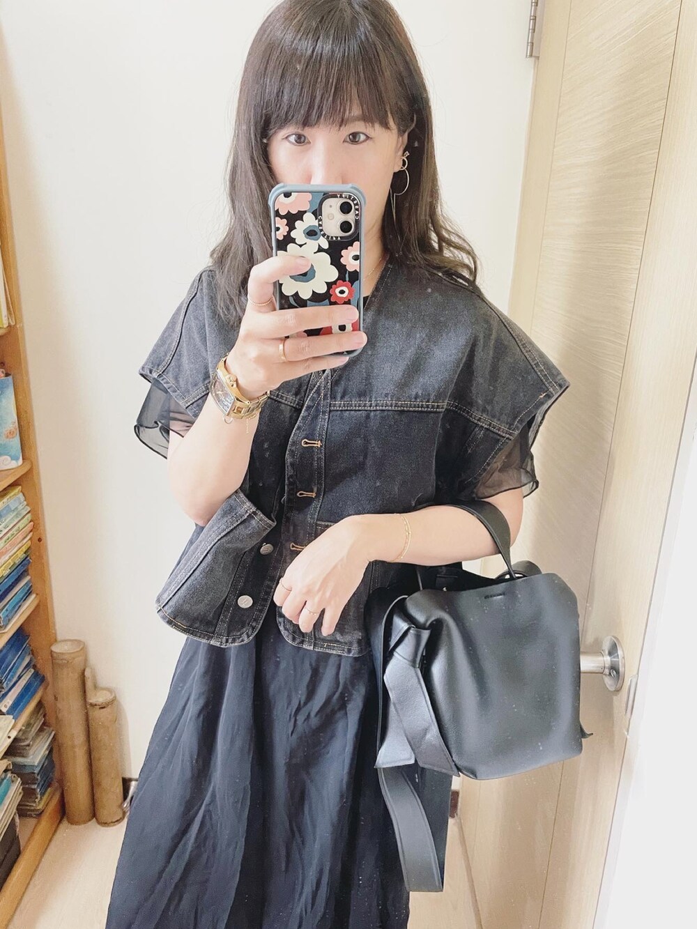 ブラック系のトートバッグ、ブラック系のシューズ、ゴールド系の腕時計を着用したレディースの夏コーディネートの3枚目の写真