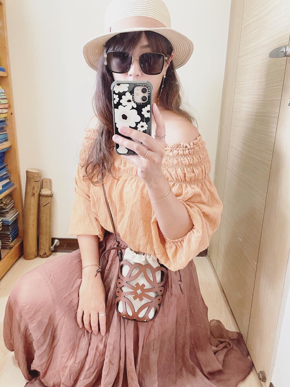 オレンジ系のトップス、ブラウン系のバッグ、ブラウン系のスカートを着用したレディースの夏コーディネートの4枚目の写真