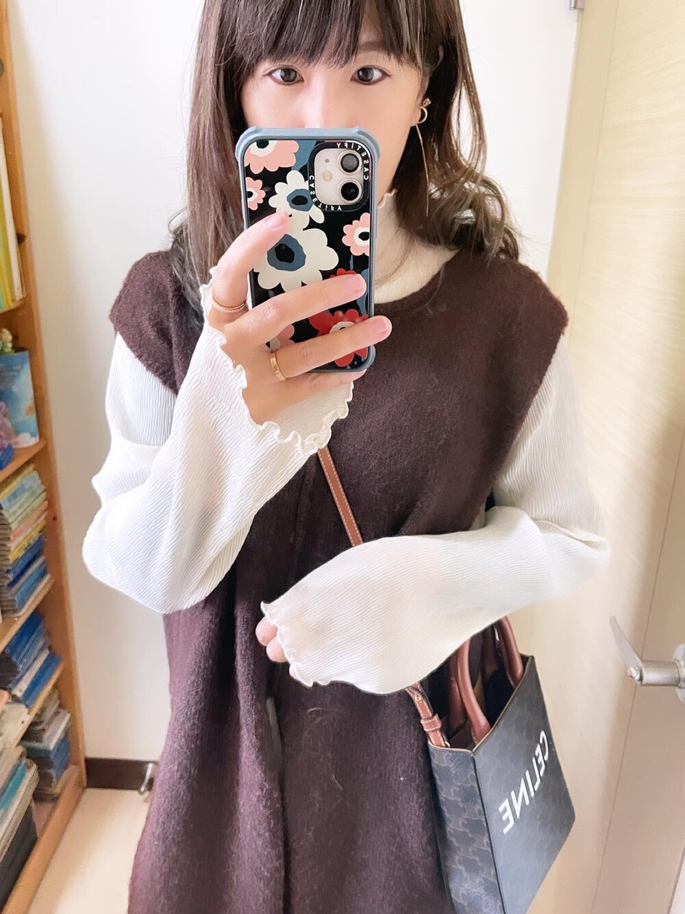 ブラック系のブーツ、ブラウン系のトップス、ブラウン系のバッグを着用したレディースの冬コーディネートの2枚目の写真