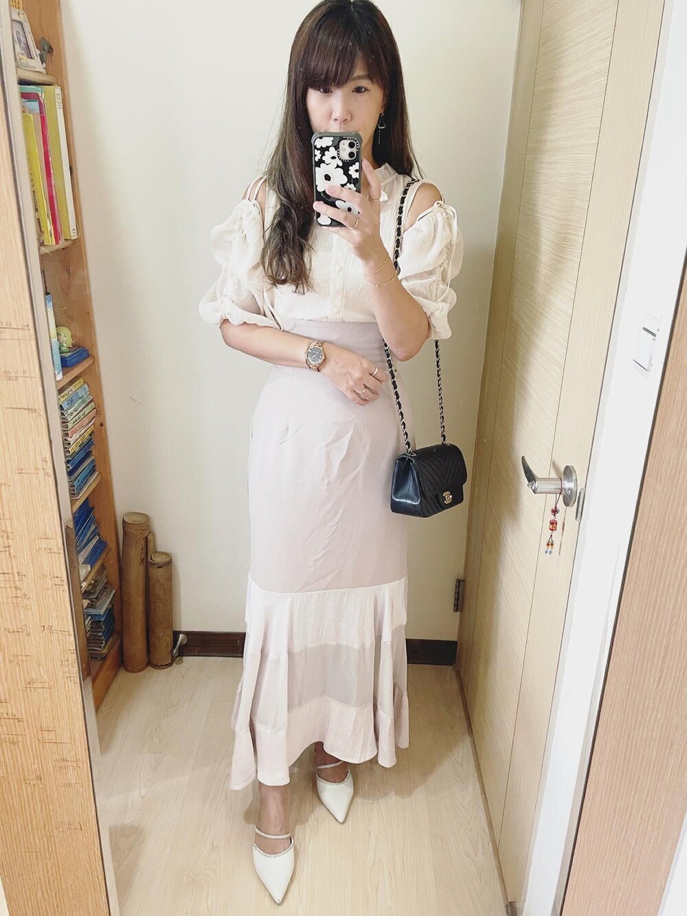 ホワイト系のシューズ、ピンク系のスカート、ブラック系のバッグを着用したレディースの秋コーディネートの2枚目の写真