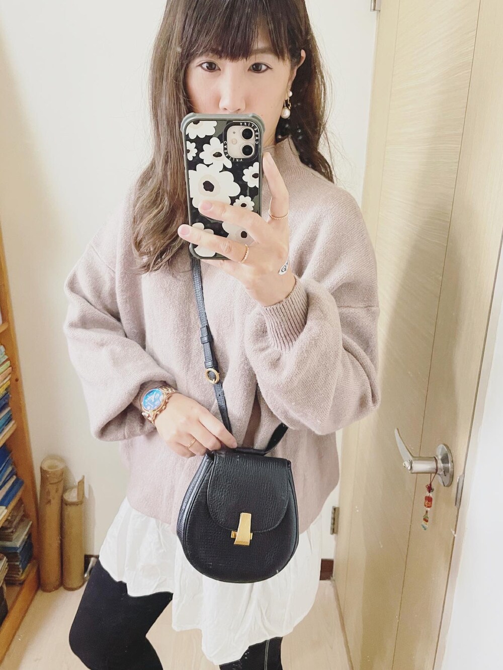 ベージュ系のニット/セーター、ブラック系のバッグ、ブラック系のブーツを着用したレディースの冬コーディネートの2枚目の写真