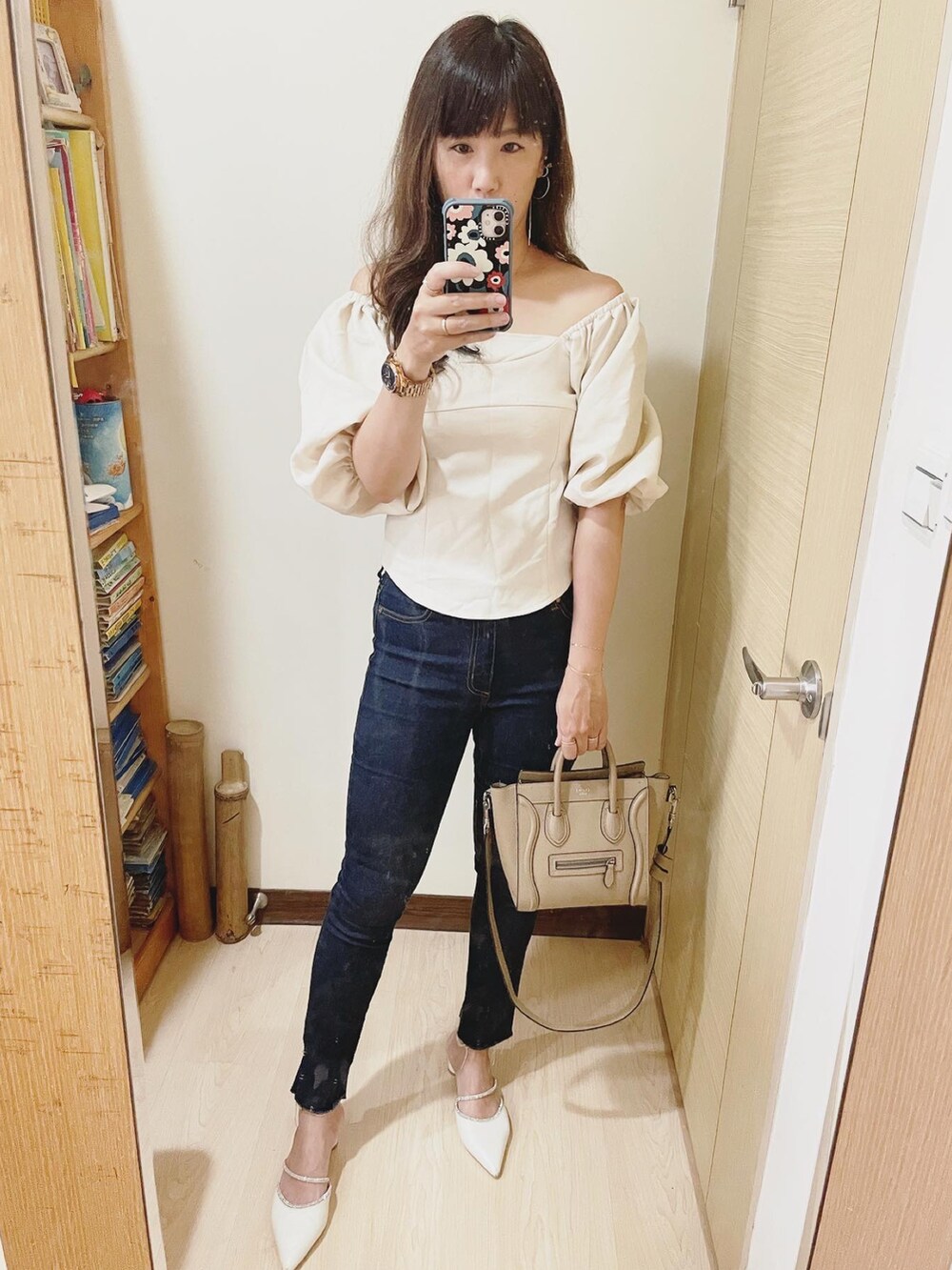 ブルー系のデニムパンツ、ホワイト系のシューズ、ベージュ系のバッグを着用したレディースの夏コーディネートの2枚目の写真