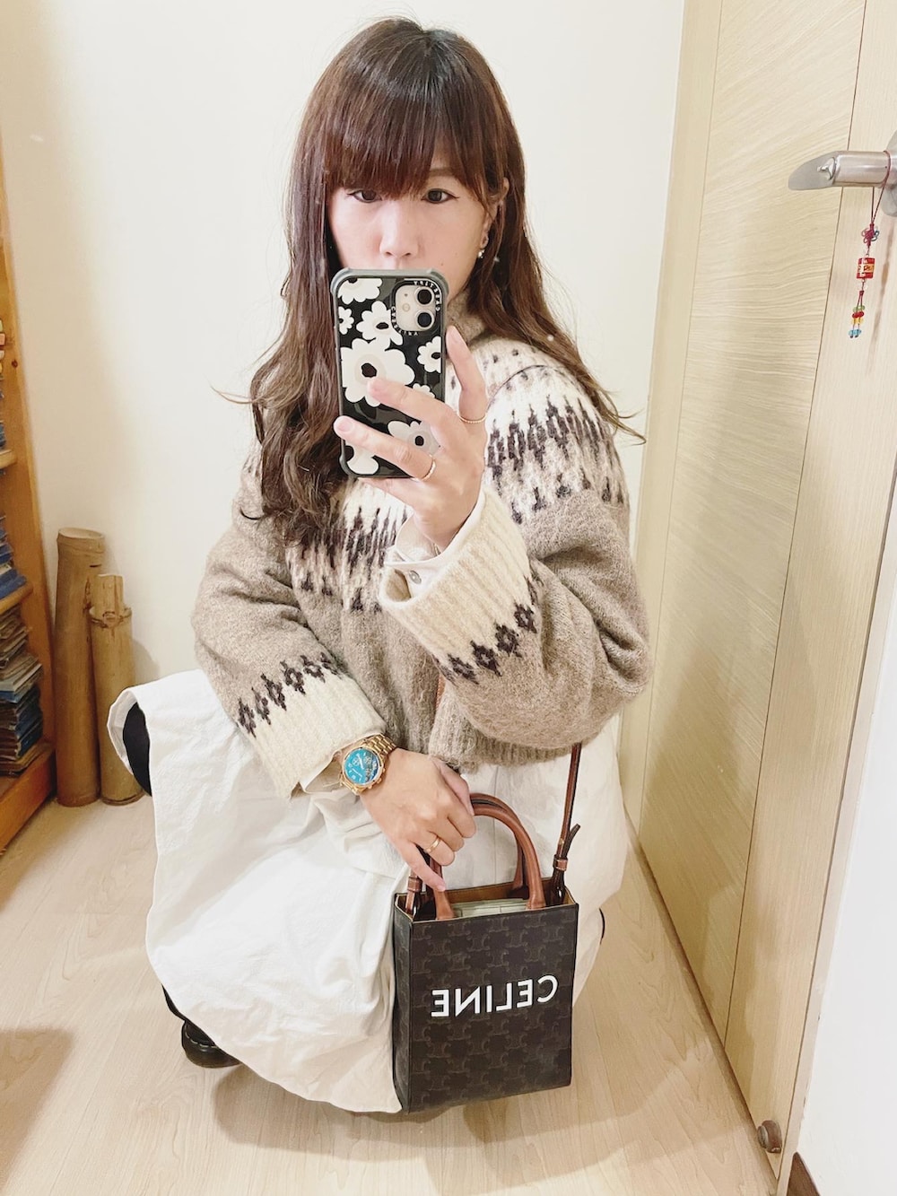 ブラウン系のニット/セーター、ホワイト系のワンピース、ブラウン系のバッグを着用したレディースの冬コーディネートの2枚目の写真