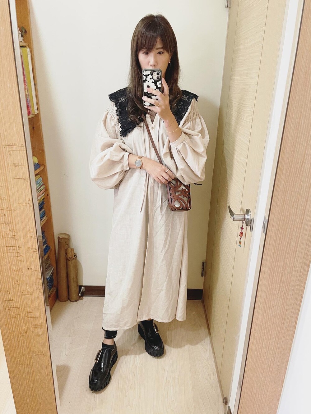 ブラウン系のベスト、ベージュ系のシャツワンピース、ブラウン系のバッグを着用したレディースの秋コーディネートの2枚目の写真