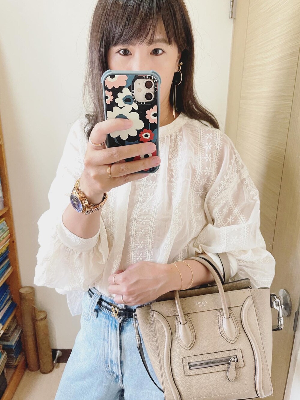 ブルー系のデニムパンツ、ホワイト系のシャツ/ブラウス、ベージュ系のバッグを着用したレディースの秋コーディネートの3枚目の写真