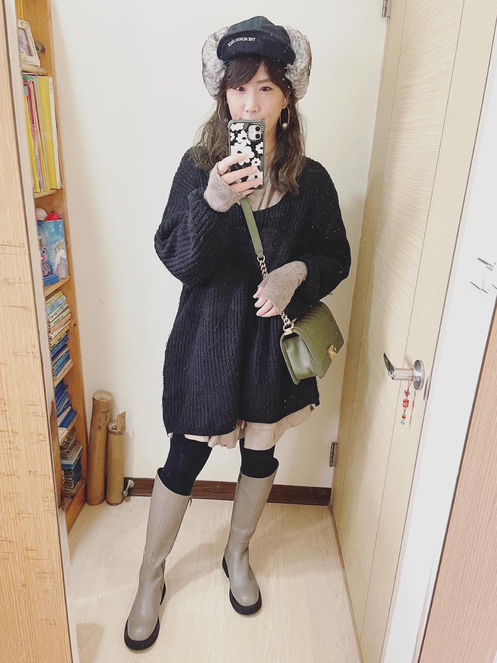 ブラック系のその他トップス、グリーン系のバッグ、ブラック系のキャップを着用したレディースの冬コーディネートの2枚目の写真