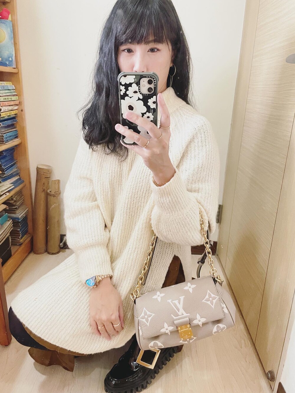 グレー系のバッグ、ホワイト系のニット/セーター、ブラウン系のワンピースを着用したレディースの冬コーディネートの3枚目の写真