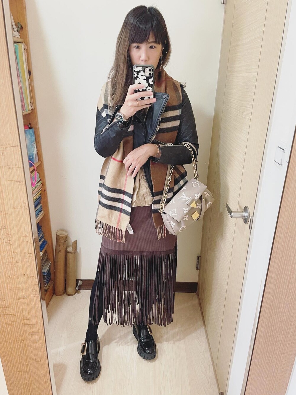 ブラック系のライダースジャケット、グレー系のバッグ、ベージュ系のシャツ/ブラウスを着用したレディースの春コーディネートの2枚目の写真