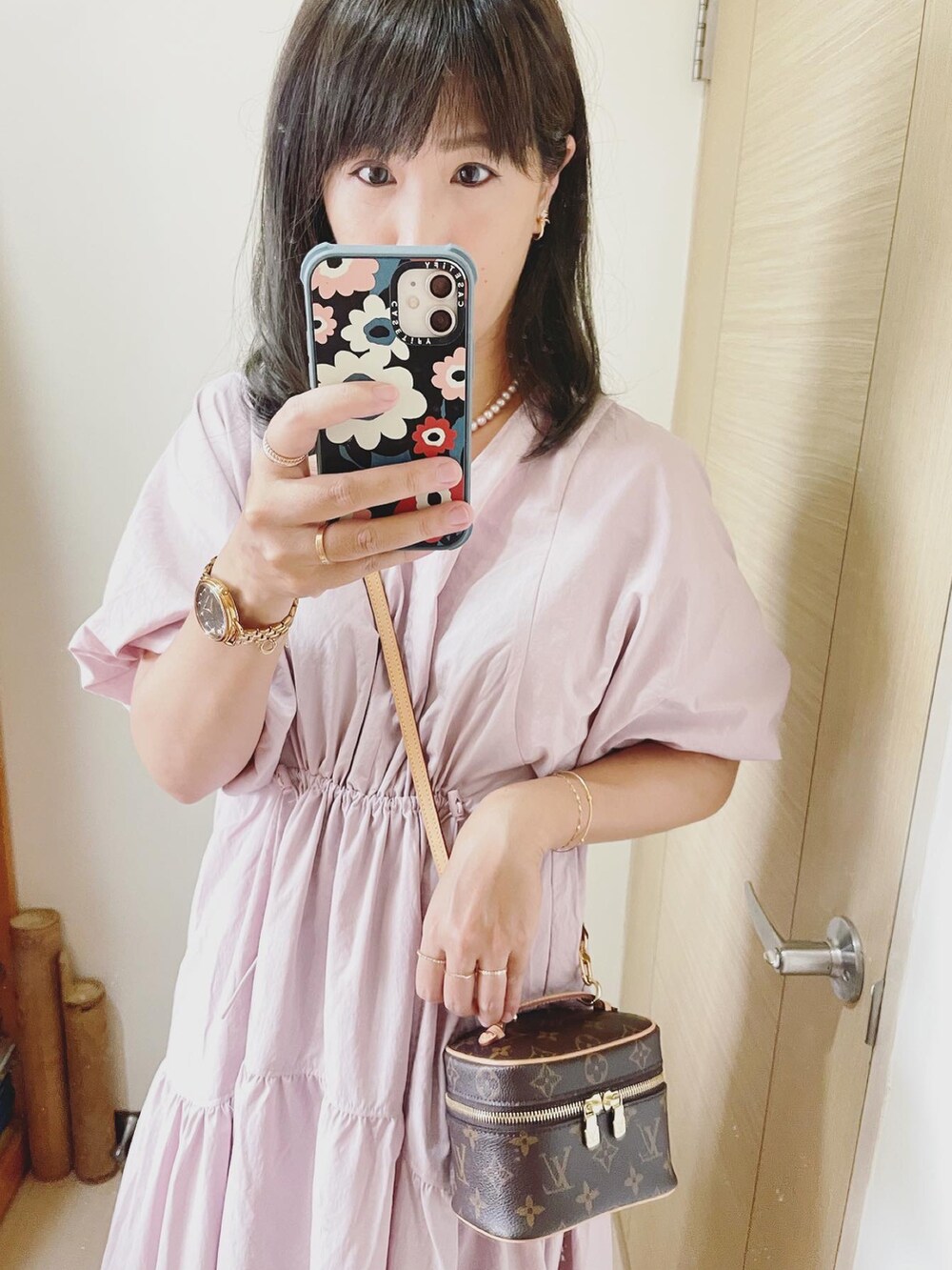 ピンク系のワンピース、ブラウン系のバッグ、ホワイト系のその他シューズを着用したレディースの夏コーディネートの3枚目の写真