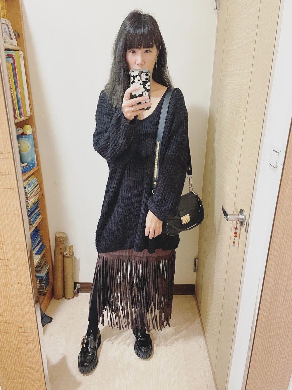 ブラック系のシューズ、ブラック系のショルダーバッグ、ブラック系のトップスを着用したレディースの冬コーディネートの2枚目の写真