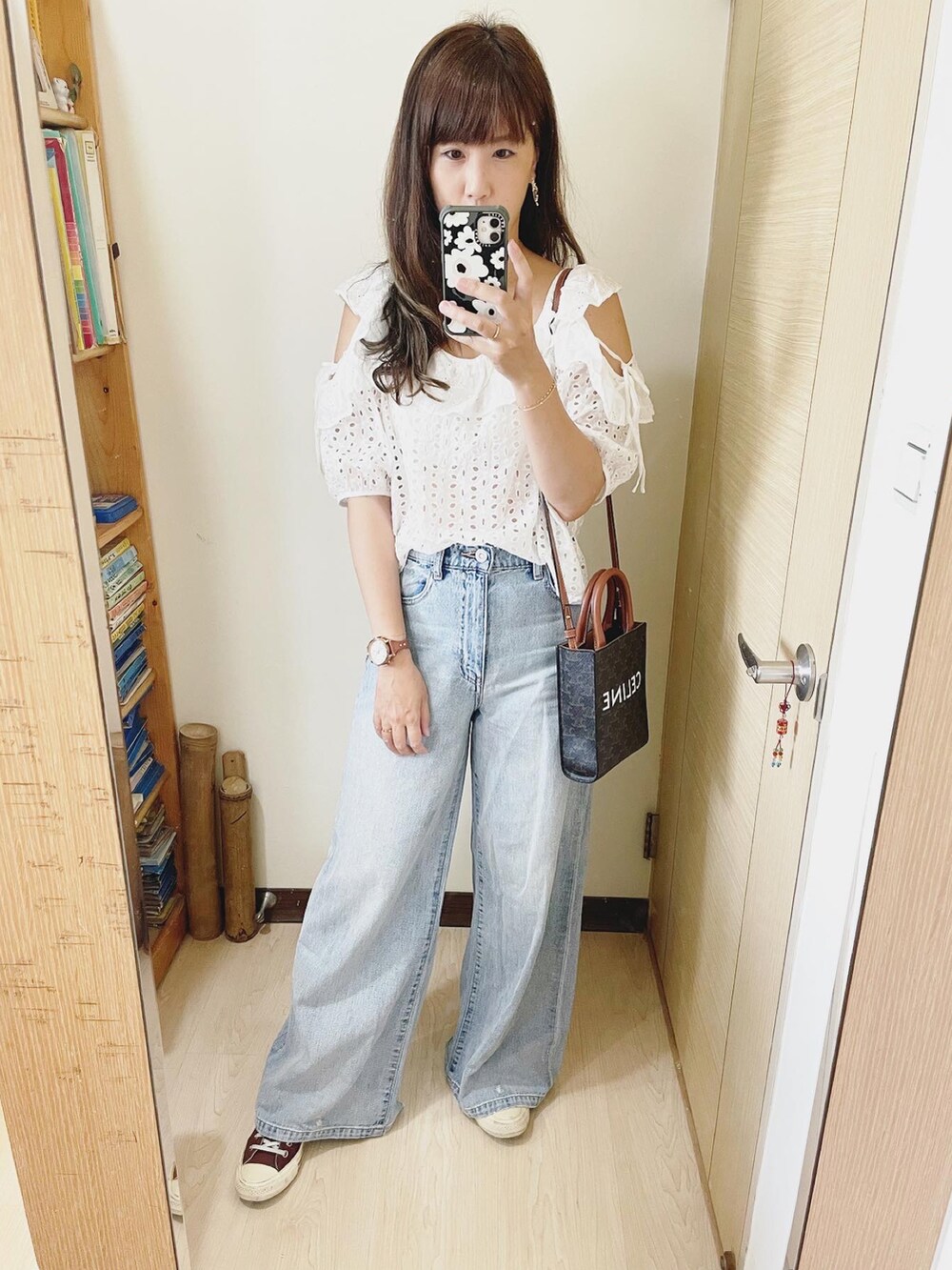 ブルー系のデニムパンツ、ホワイト系のシャツ/ブラウス、ブラウン系のバッグを着用したレディースの夏コーディネートの2枚目の写真