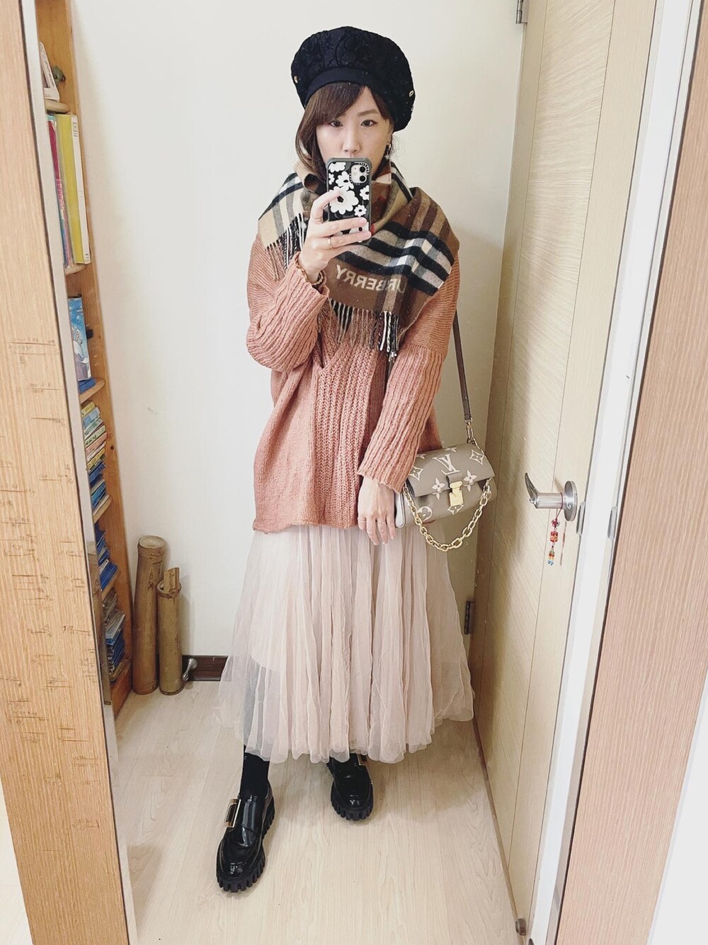 グレー系のバッグ、ブラウン系のニット/セーター、ホワイト系のスカートを着用したレディースの冬コーディネートの2枚目の写真