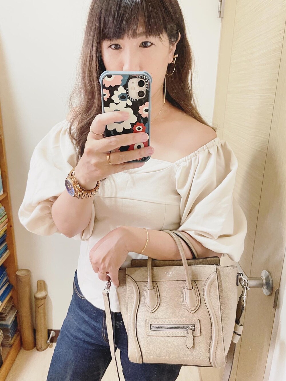 ブルー系のデニムパンツ、ホワイト系のシューズ、ベージュ系のバッグを着用したレディースの夏コーディネートの3枚目の写真