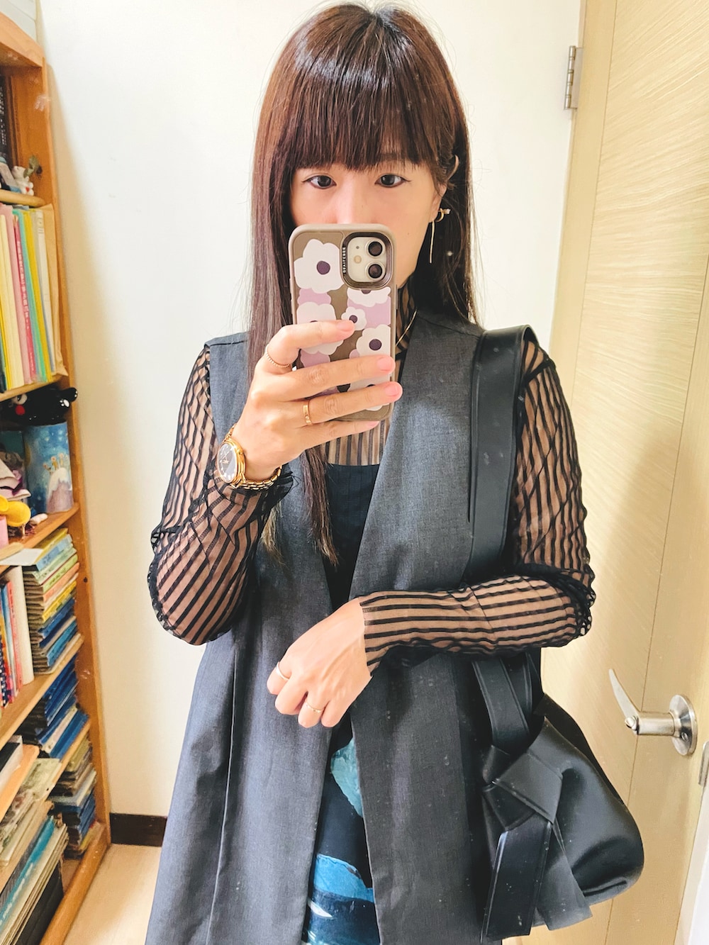 ホワイト系のスカート、ブラック系のトートバッグ、ブラック系のブーツを着用したレディースの秋コーディネートの3枚目の写真