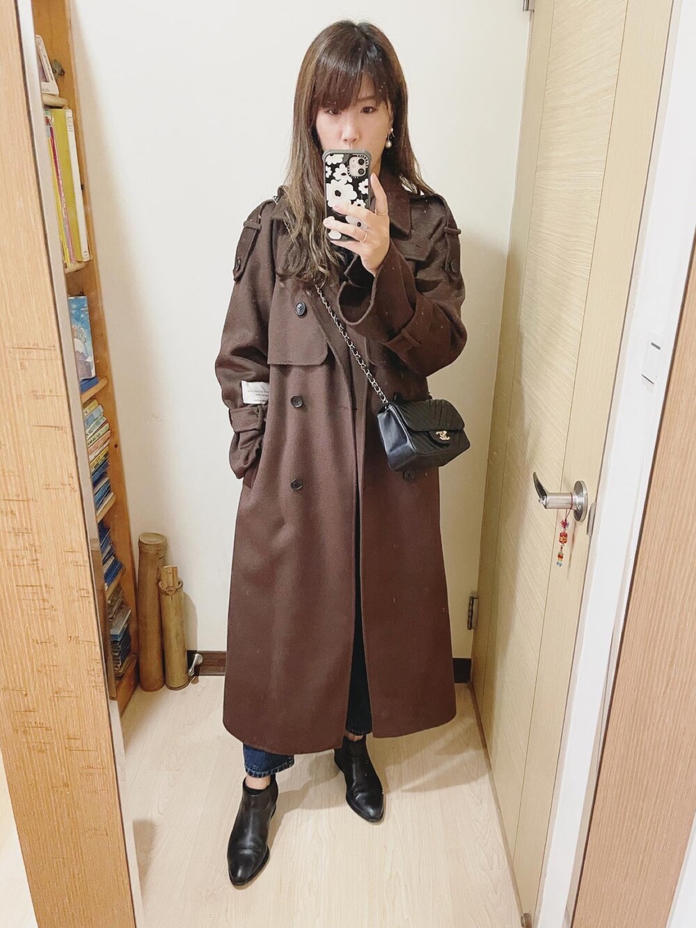 ブラック系のバッグ、ブラック系のブーツ、ブラウン系のその他アウターを着用したレディースの冬コーディネートの2枚目の写真