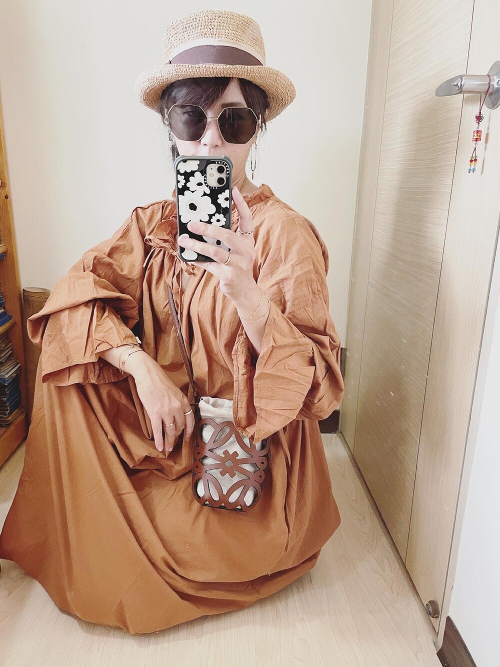 ブラック系のサンダル、ブラウン系のワンピース、ブラウン系のバッグを着用したレディースの夏コーディネートの2枚目の写真