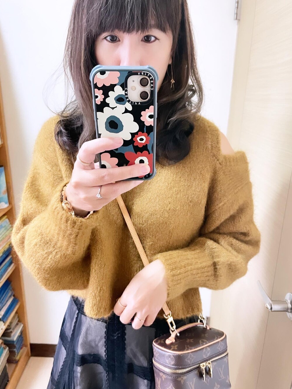 ブラック系のスカート、イエロー系のトップス、ブラウン系のバッグを着用したレディースの冬コーディネートの3枚目の写真