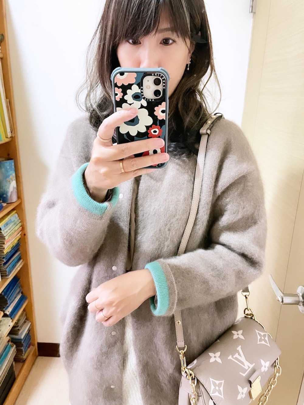 ベージュ系のカーディガン/ボレロ、グレー系のバッグ、ホワイト系のスカートを着用したレディースの冬コーディネートの2枚目の写真