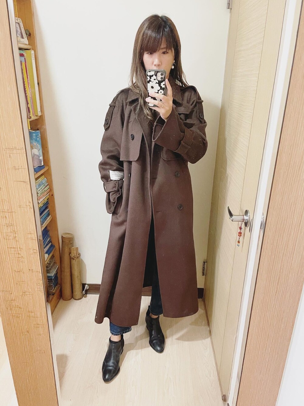 ブラック系のバッグ、ブラック系のブーツ、ブラウン系のその他アウターを着用したレディースの冬コーディネートの3枚目の写真