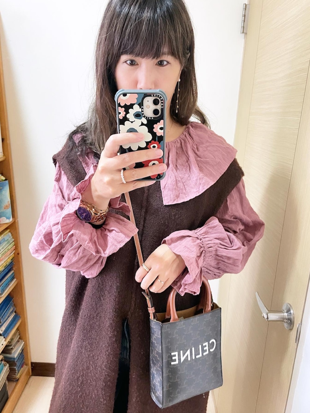 ブラック系のシューズ、ブラウン系のバッグ、ブルー系のデニムパンツを着用したレディースの冬コーディネートの2枚目の写真