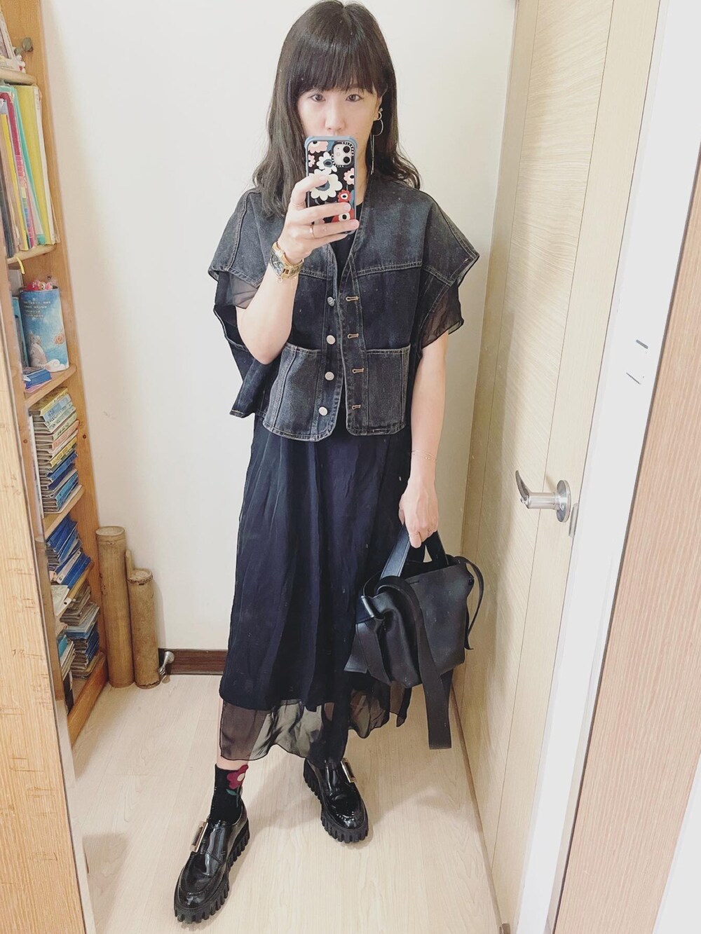 ブラック系のトートバッグ、ブラック系のシューズ、ゴールド系の腕時計を着用したレディースの夏コーディネートの2枚目の写真