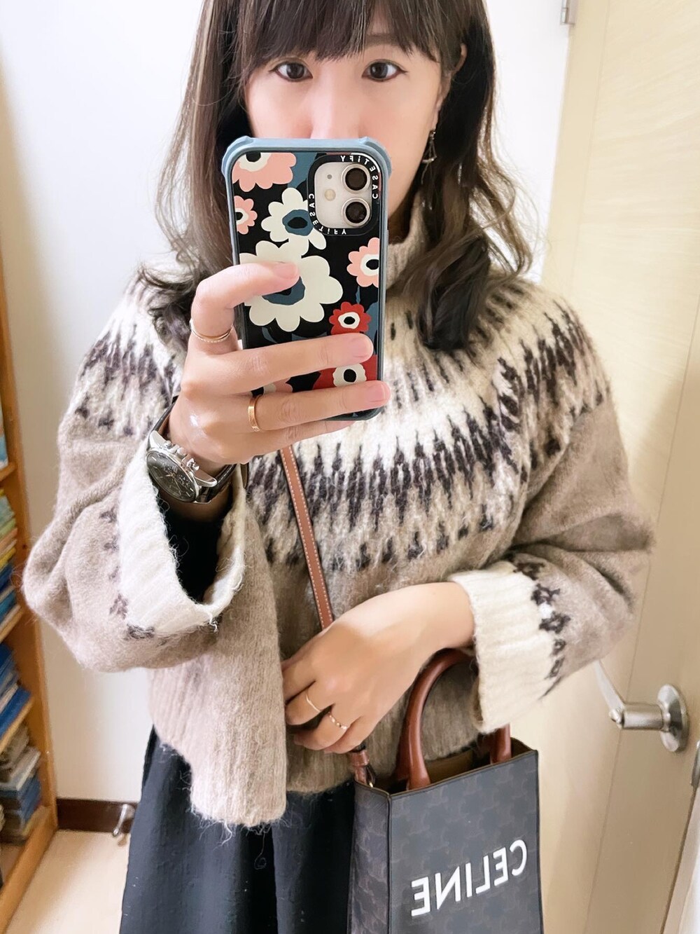 ブラウン系のニット/セーター、ブラウン系のバッグ、ブラック系のワンピースを着用したレディースの冬コーディネートの2枚目の写真