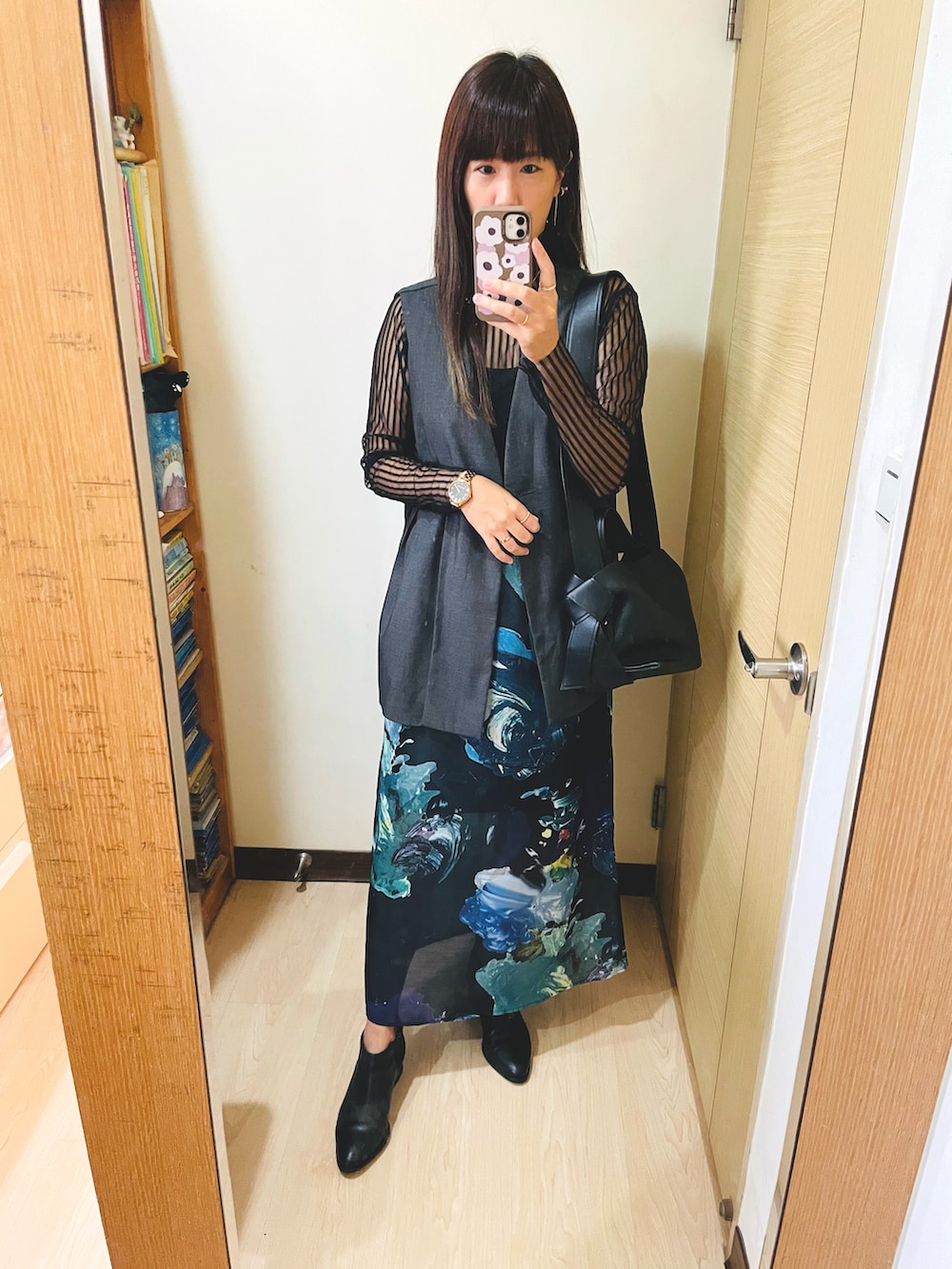 ホワイト系のスカート、ブラック系のトートバッグ、ブラック系のブーツを着用したレディースの秋コーディネートの2枚目の写真