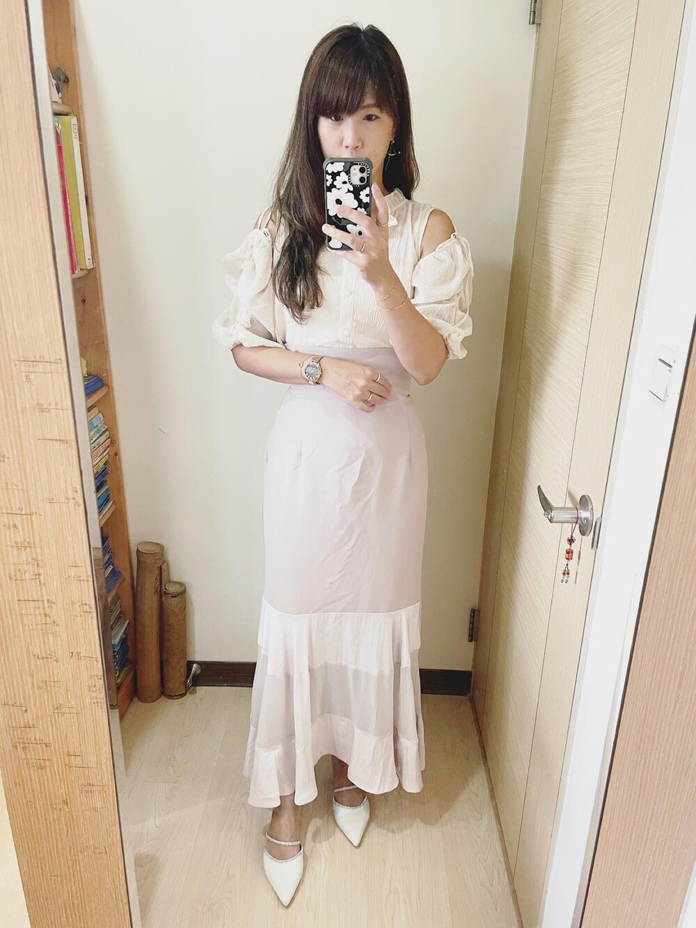 ホワイト系のシューズ、ピンク系のスカート、ブラック系のバッグを着用したレディースの秋コーディネートの3枚目の写真