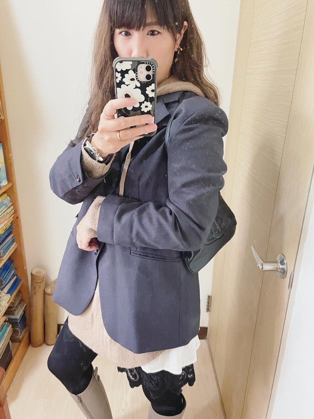 ブラウン系のパーカー、ブラック系のクラッチバッグ、グリーン系のアナログ腕時計を着用したレディースの春コーディネートの2枚目の写真