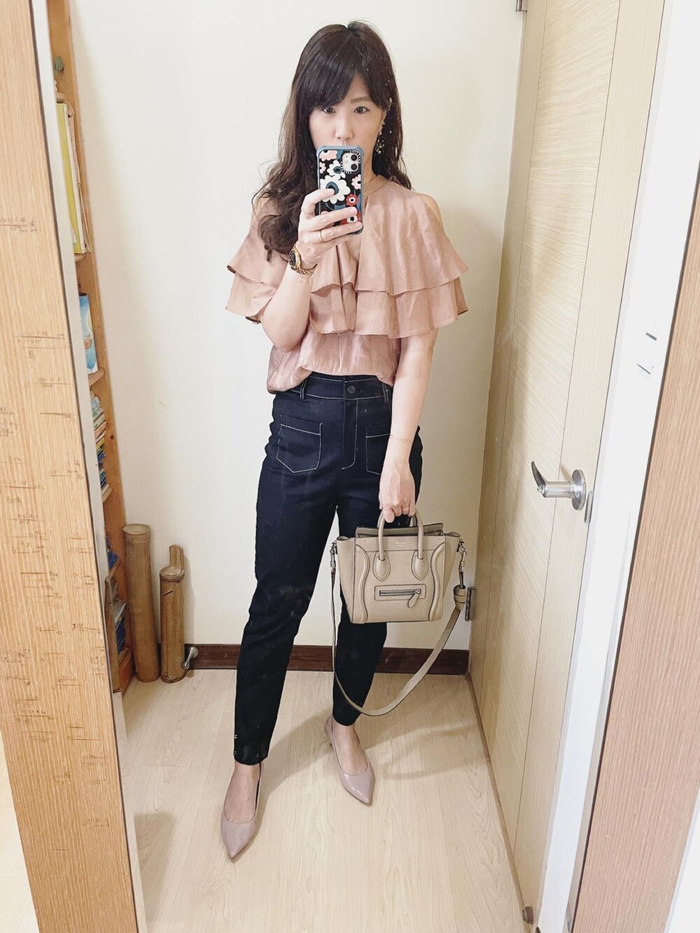 ベージュ系のトップス、ベージュ系のバッグ、ピンク系のシューズを着用したレディースの夏コーディネートの2枚目の写真