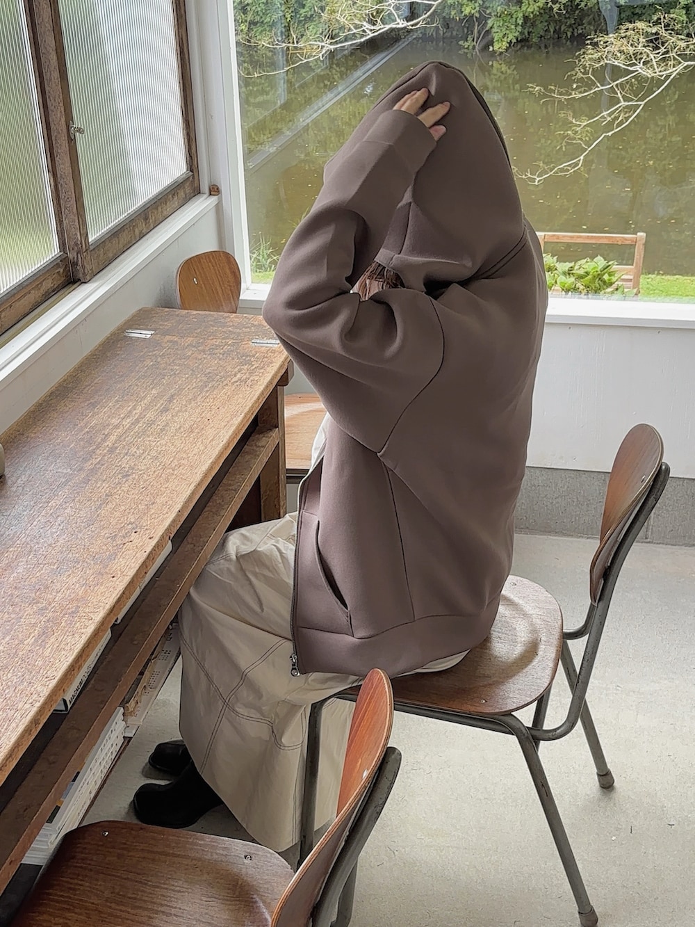 ブラウン系のパーカー、ホワイト系のワンピース、ブラウン系のブーツを着用したレディースの秋コーディネートの4枚目の写真