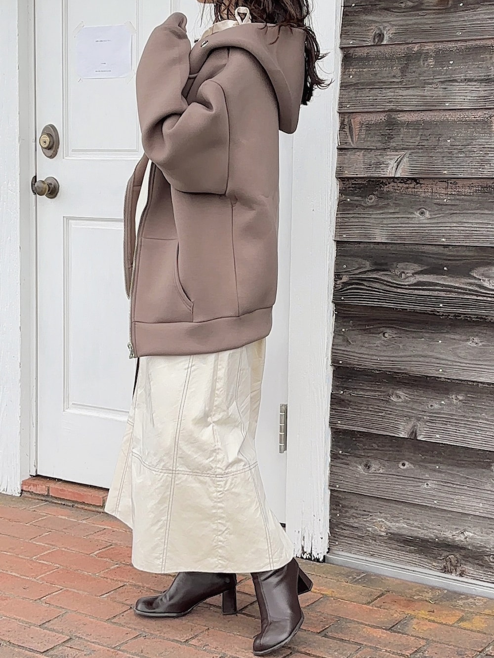 ブラウン系のパーカー、ホワイト系のワンピース、ブラウン系のブーツを着用したレディースの秋コーディネートの3枚目の写真