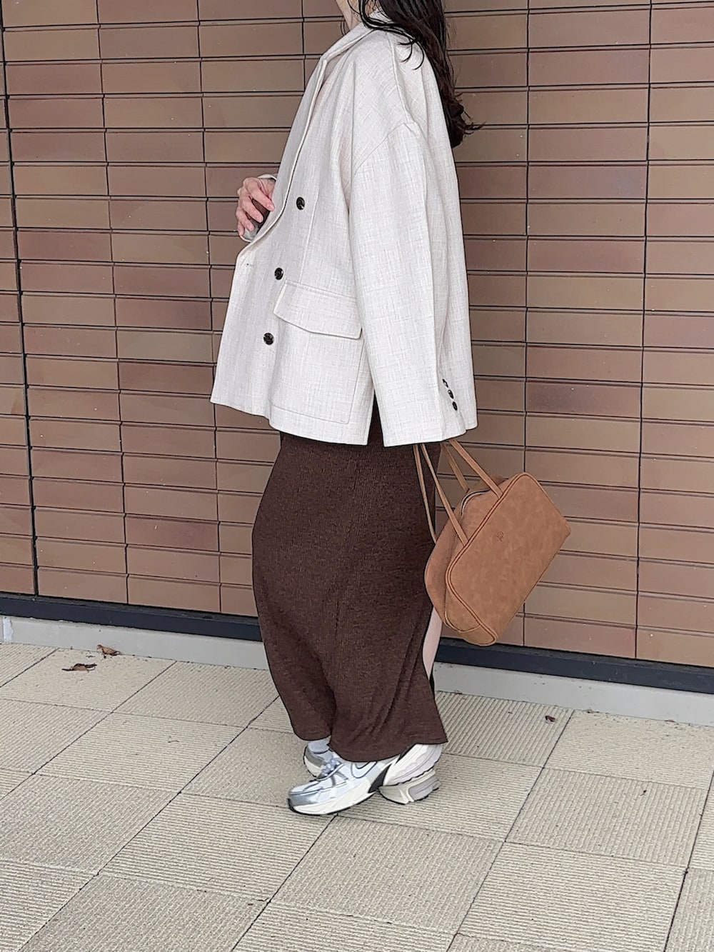 ホワイト系のスニーカー、ベージュ系のテーラードジャケット、ブラウン系のボストンバッグを着用したレディースの秋コーディネートの2枚目の写真