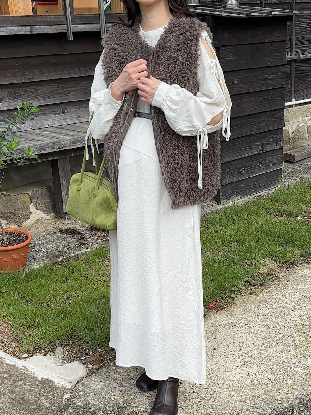 ホワイト系のワンピース、グリーン系のボストンバッグ、ブラウン系のブーツを着用したレディースの秋コーディネートの2枚目の写真