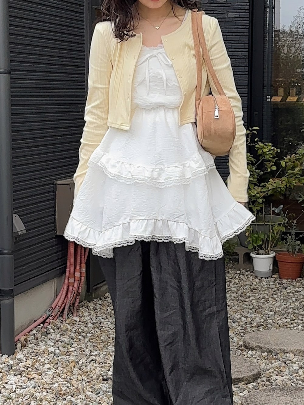 ベージュ系のボストンバッグ、ホワイト系のワンピース/ドレス、イエロー系のカーディガン/ボレロを着用したレディースの春コーディネートの3枚目の写真