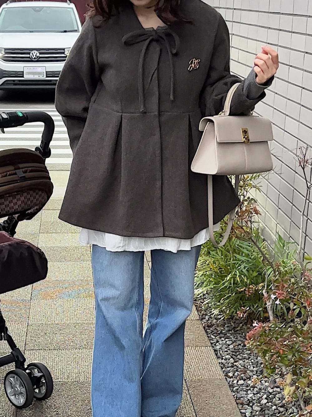 グレー系のその他アウター、グレー系のショルダーバッグ、ホワイト系のスカートを着用したレディースの冬コーディネートの3枚目の写真