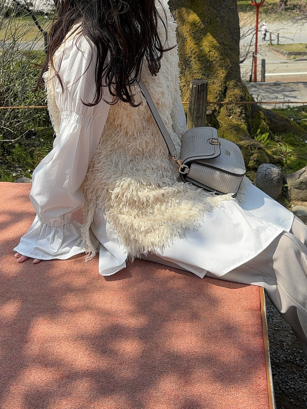 ホワイト系のベスト、ホワイト系のシャツ/ブラウス、ベージュ系のショルダーバッグを着用したレディースの春コーディネートの5枚目の写真