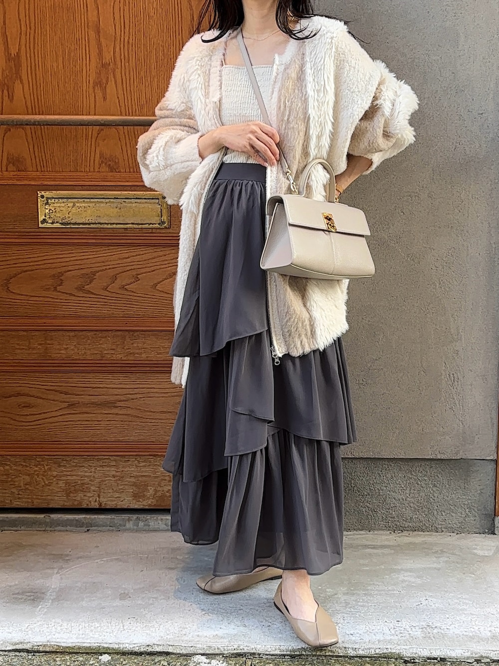 ホワイト系のカーディガン/ボレロ、グレー系のセットアップ、グレー系のパンプスを着用したレディースの秋コーディネートの4枚目の写真