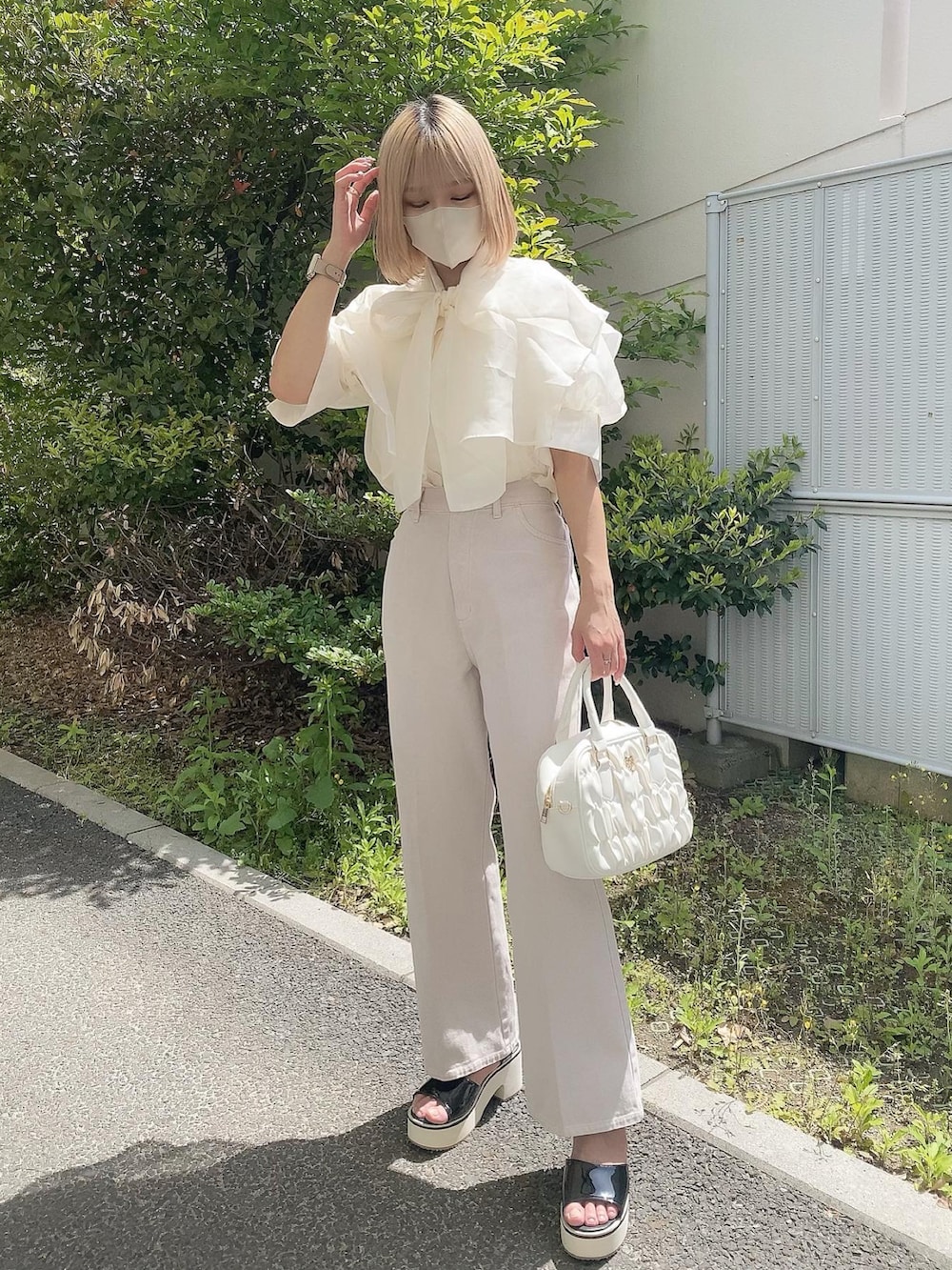 ホワイト系のボストンバッグ、ホワイト系のシャツ/ブラウス、ピンク系のデニムパンツを着用したレディースの春コーディネートの3枚目の写真