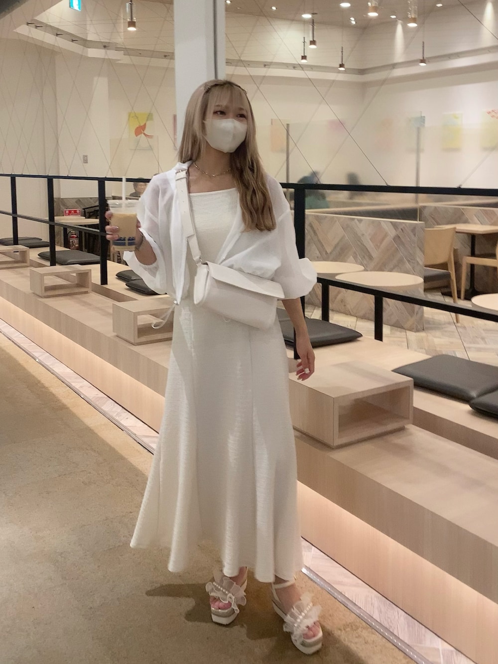 ホワイト系のサンダル、ホワイト系のワンピース、ホワイト系のマウンテンパーカーを着用したレディースの春コーディネートの4枚目の写真