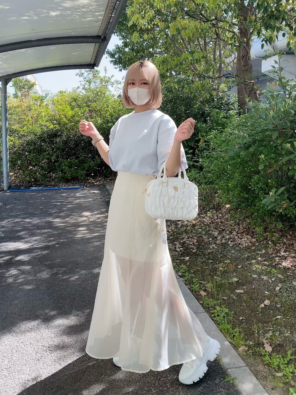 ホワイト系のボストンバッグ、ブルー系のTシャツ/カットソー、ホワイト系のスニーカーを着用したレディースの春コーディネートの4枚目の写真