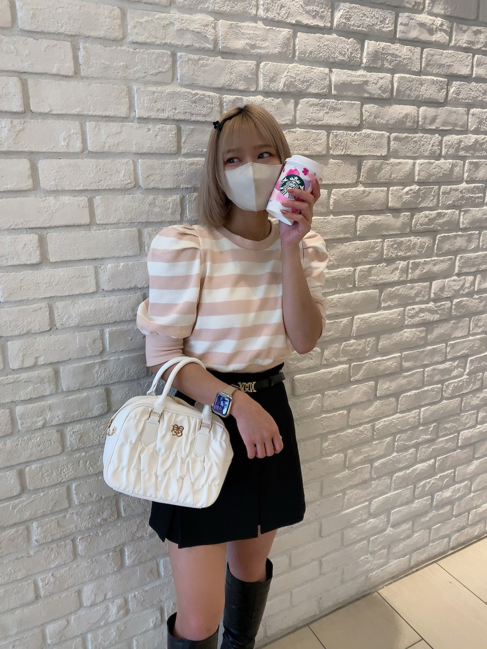 ピンク系のTシャツ/カットソー、ブラック系のスカート、ホワイト系のボストンバッグを着用したレディースの春コーディネートの4枚目の写真