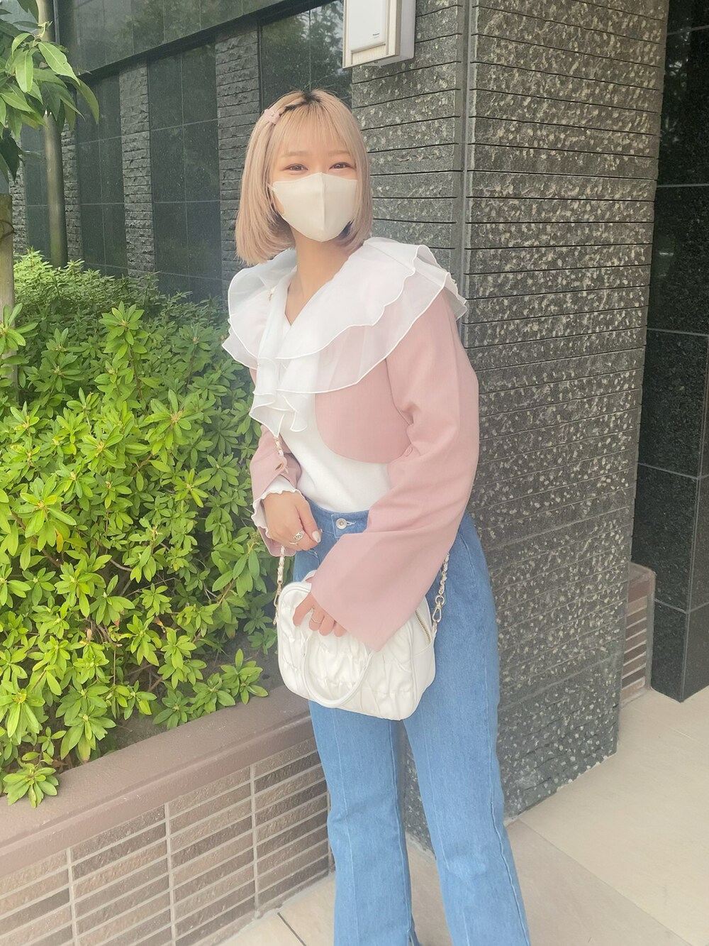 ブルー系のデニムパンツ、ホワイト系のボストンバッグ、ホワイト系のTシャツ/カットソーを着用したレディースの春コーディネートの4枚目の写真