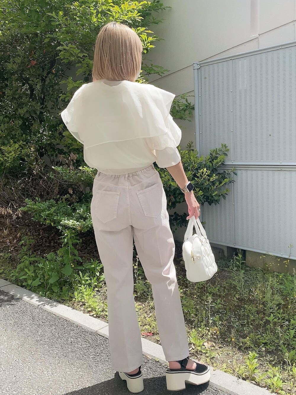 ホワイト系のボストンバッグ、ホワイト系のシャツ/ブラウス、ピンク系のデニムパンツを着用したレディースの春コーディネートの4枚目の写真