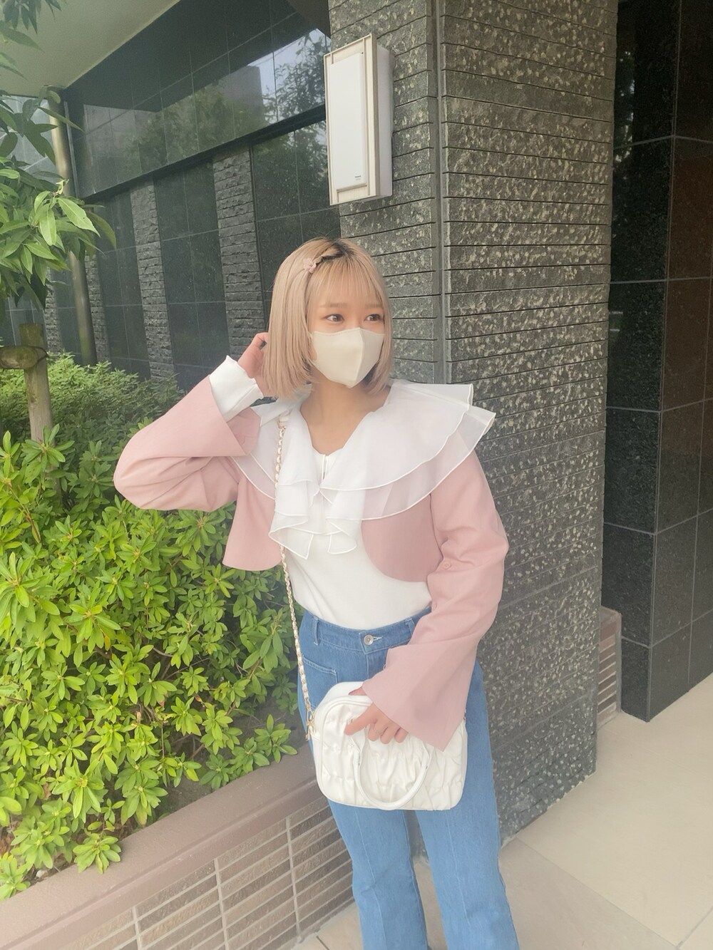 ブルー系のデニムパンツ、ホワイト系のボストンバッグ、ホワイト系のTシャツ/カットソーを着用したレディースの春コーディネートの3枚目の写真